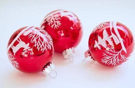 Red Christmas baubles with white festive designs perfect for holiday decor.